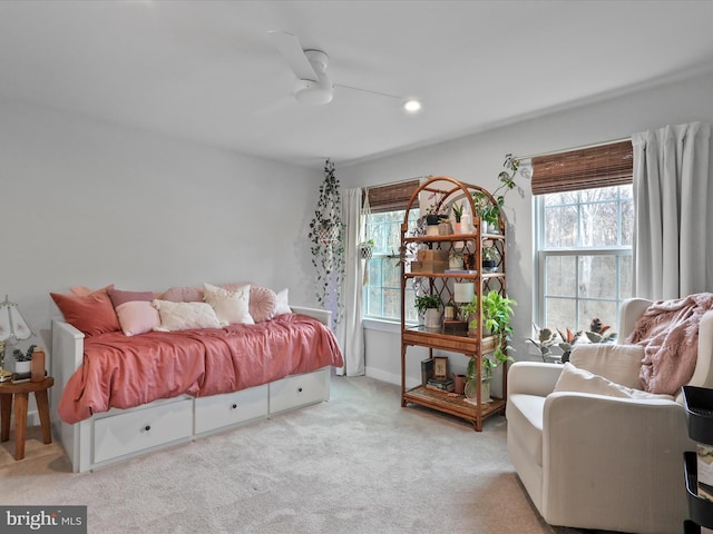 bedroom featuring multiple windows, light colored carpet, and ceiling fan