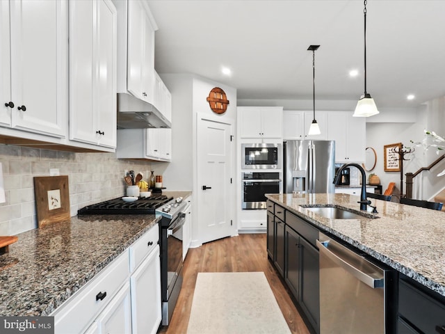 kitchen with white cabinetry, sink, hanging light fixtures, and appliances with stainless steel finishes