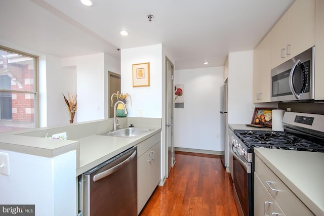 kitchen featuring dark wood-type flooring, appliances with stainless steel finishes, and sink