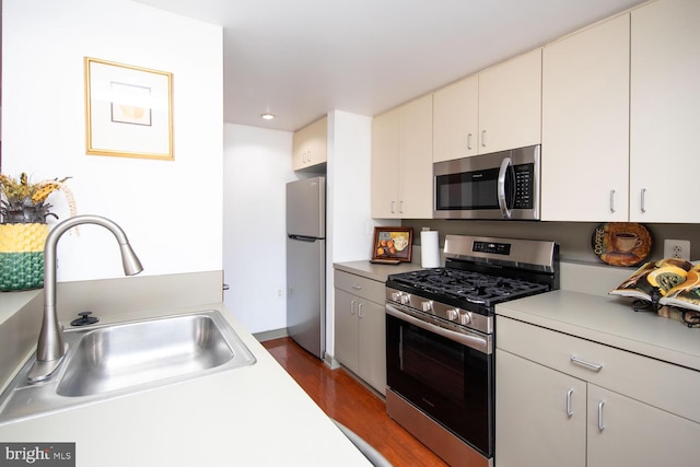 kitchen with stainless steel appliances, dark hardwood / wood-style floors, sink, and white cabinets