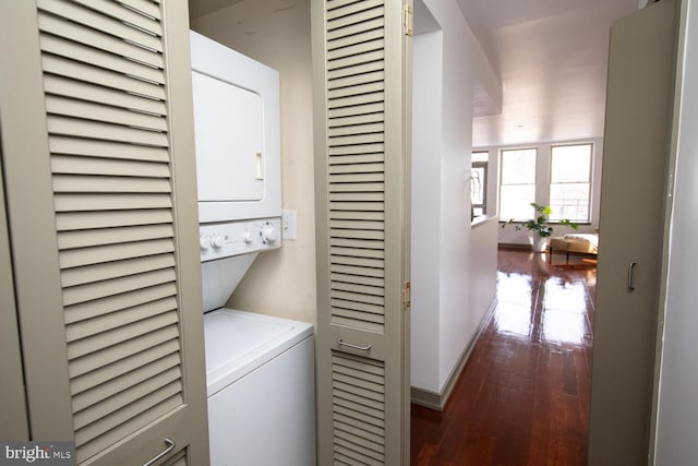 washroom featuring stacked washer / drying machine and dark hardwood / wood-style floors