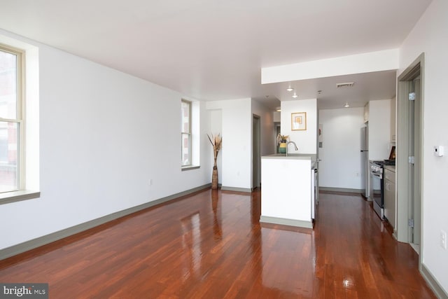 unfurnished living room with sink and dark hardwood / wood-style floors