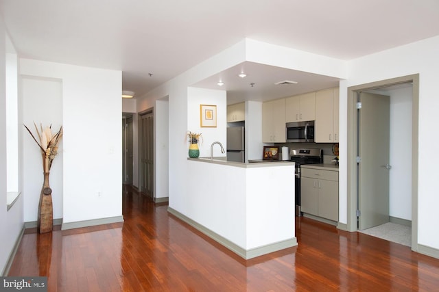 kitchen featuring sink, wood-type flooring, stainless steel appliances, and kitchen peninsula