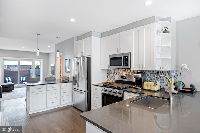 kitchen featuring sink, appliances with stainless steel finishes, hanging light fixtures, white cabinets, and kitchen peninsula