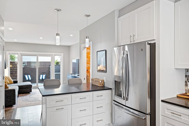 kitchen featuring white cabinetry, kitchen peninsula, stainless steel fridge with ice dispenser, and hanging light fixtures