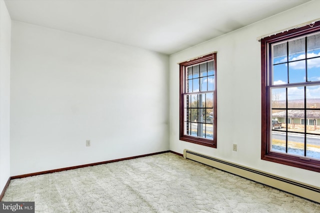 carpeted spare room with baseboard heating