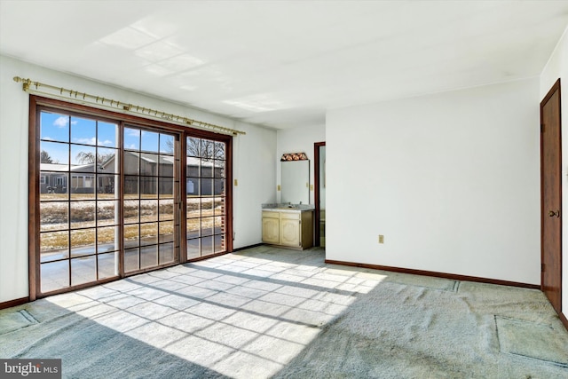 unfurnished room with light colored carpet and sink