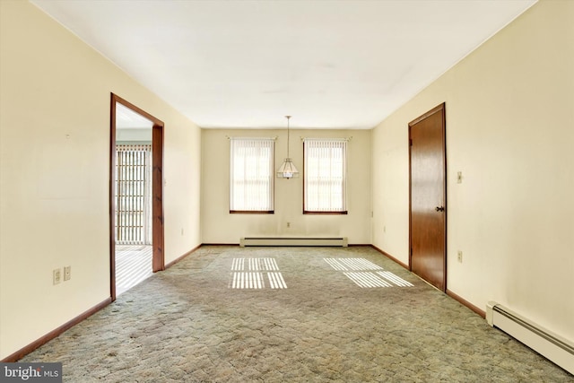 carpeted empty room featuring a baseboard heating unit