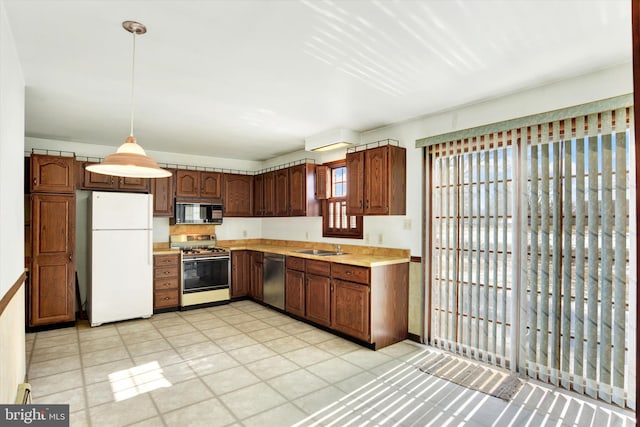 kitchen with pendant lighting, stainless steel appliances, and sink