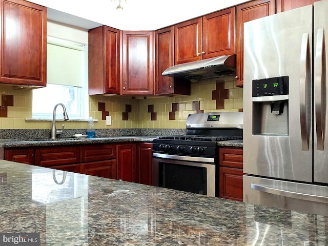 kitchen with dark stone countertops, sink, decorative backsplash, and appliances with stainless steel finishes