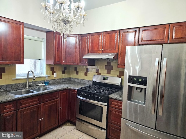 kitchen featuring sink, light tile patterned floors, stainless steel appliances, decorative backsplash, and dark stone counters