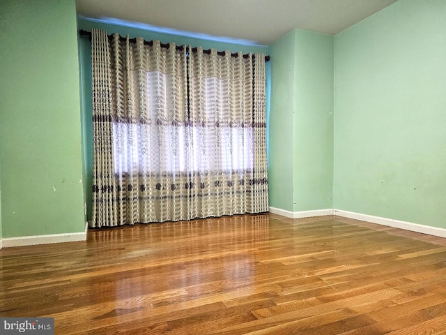 unfurnished room with wood-type flooring