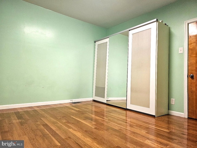 unfurnished bedroom with hardwood / wood-style flooring and a closet