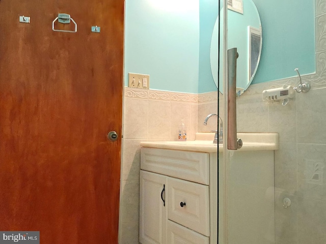 bathroom with vanity and tile walls