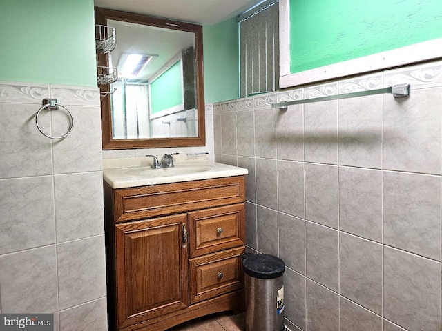 bathroom with vanity and tile walls