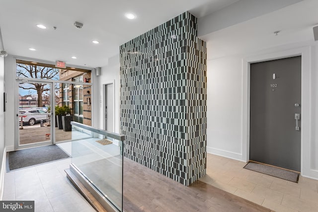 corridor with baseboards, recessed lighting, and light tile patterned flooring