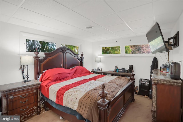 bedroom with light carpet and a drop ceiling