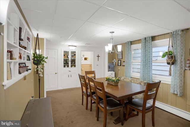 dining room featuring a baseboard radiator, a chandelier, a paneled ceiling, and dark carpet