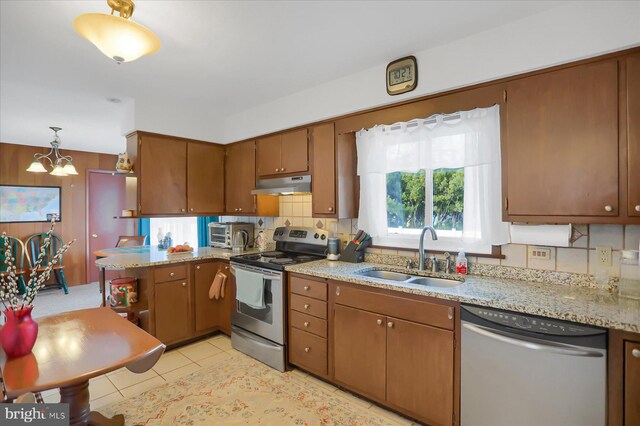 kitchen with decorative light fixtures, sink, decorative backsplash, and stainless steel appliances