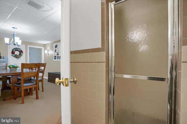 interior space with an enclosed shower and a notable chandelier