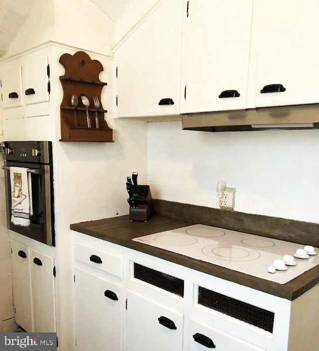 kitchen with white cabinetry, white electric cooktop, decorative backsplash, and oven