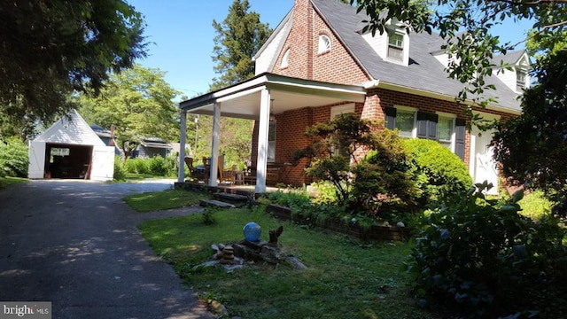 view of side of home featuring a garage, an outdoor structure, and a lawn