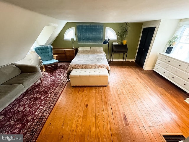 bedroom with vaulted ceiling and light hardwood / wood-style floors