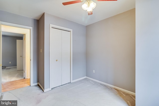 unfurnished bedroom featuring ceiling fan, light colored carpet, and a closet