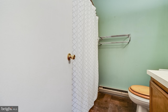 bathroom with vanity, toilet, and a baseboard heating unit