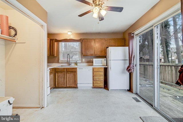 kitchen featuring ceiling fan, sink, and white appliances