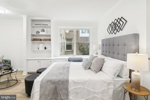 bedroom featuring ornamental molding and light hardwood / wood-style floors