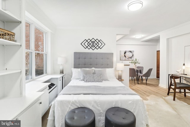 bedroom featuring crown molding and light hardwood / wood-style flooring