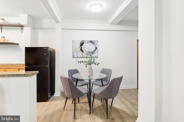 dining space featuring ornamental molding and light wood-type flooring