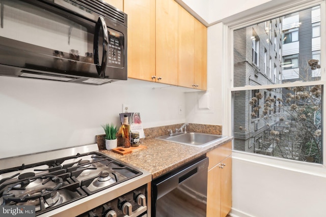 kitchen with sink, light brown cabinets, and black appliances