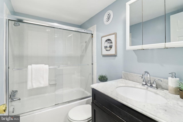 full bathroom with vanity, toilet, and combined bath / shower with glass door