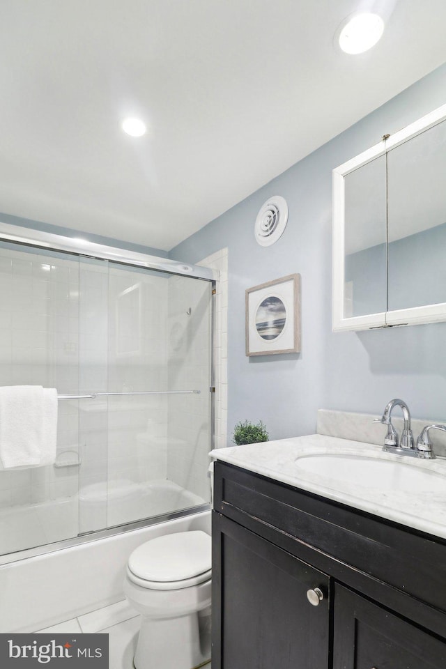 full bathroom with vanity, shower / bath combination with glass door, and toilet