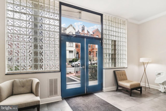 entryway with ornamental molding and tile patterned flooring