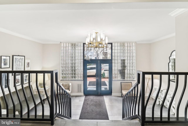 foyer featuring ornamental molding, an inviting chandelier, and french doors