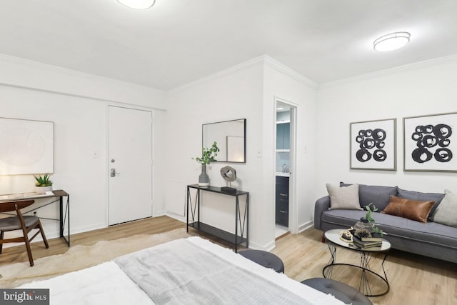 bedroom featuring wood-type flooring, ensuite bathroom, and crown molding