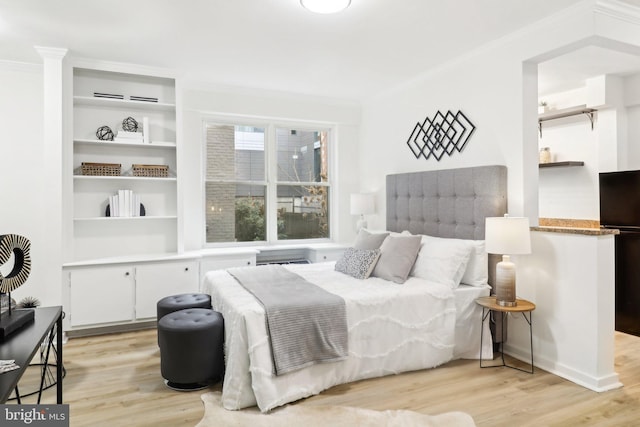 bedroom with crown molding, an AC wall unit, and light hardwood / wood-style floors