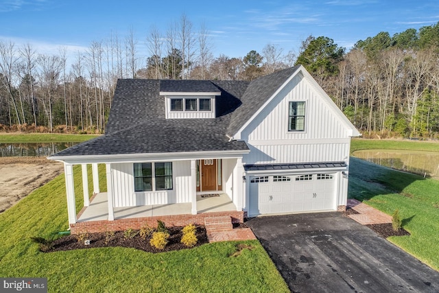 view of front facade featuring a garage, covered porch, and a front lawn