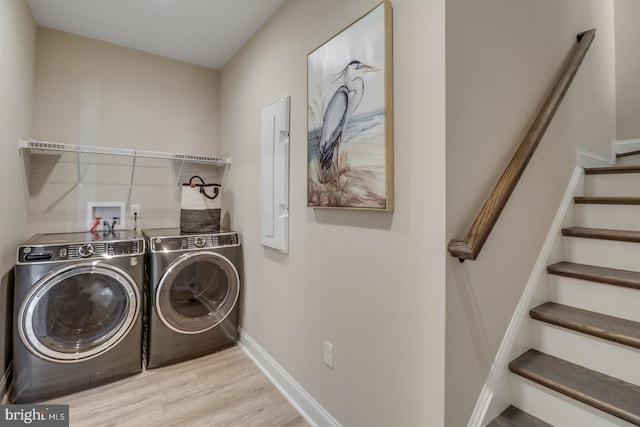 laundry area with washer and clothes dryer and light hardwood / wood-style flooring