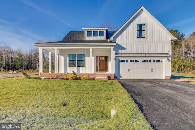 view of front of property with a garage, a front yard, and covered porch