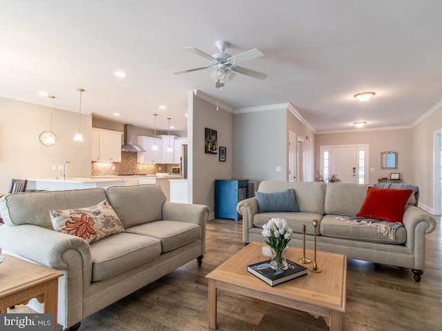 living room with ornamental molding, dark hardwood / wood-style floors, sink, and ceiling fan