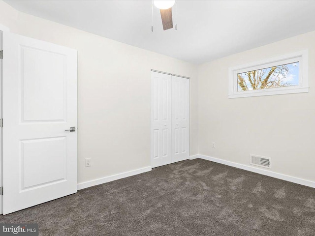 unfurnished bedroom with a closet, ceiling fan, and dark colored carpet