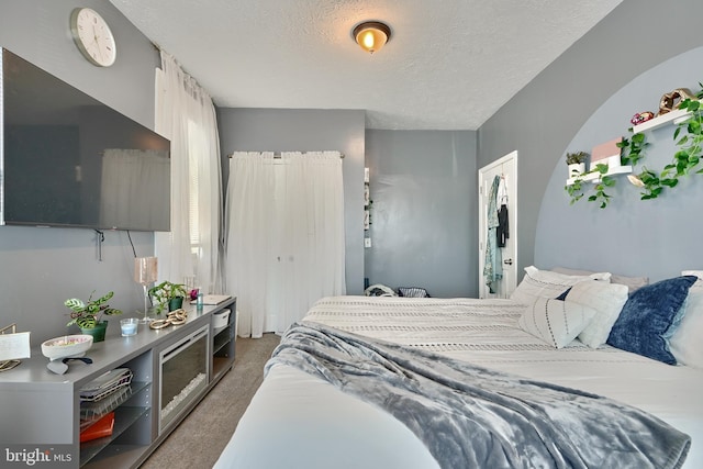 carpeted bedroom featuring a textured ceiling