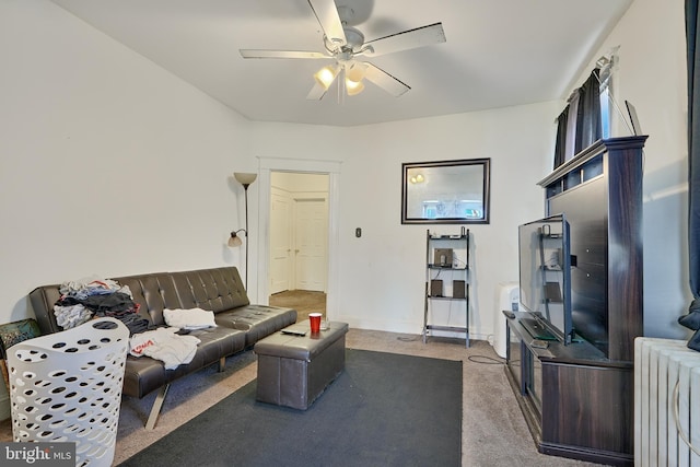 living room featuring radiator heating unit, ceiling fan, and dark colored carpet