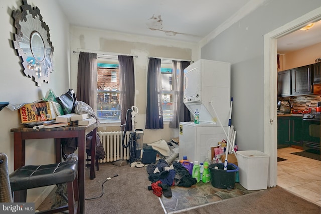 interior space with stacked washer and clothes dryer, radiator, and light carpet