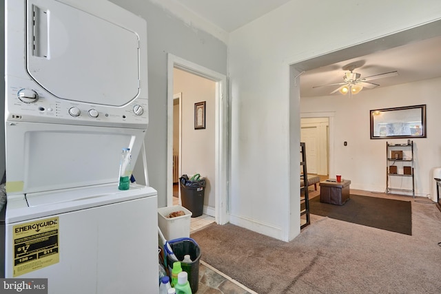 clothes washing area featuring stacked washer / drying machine, ceiling fan, and carpet