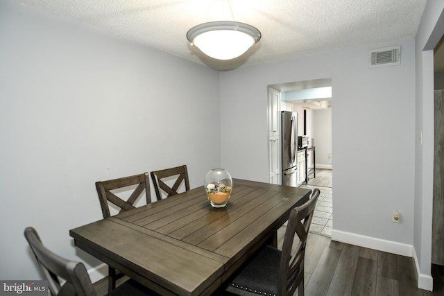 dining area featuring dark hardwood / wood-style floors and a textured ceiling